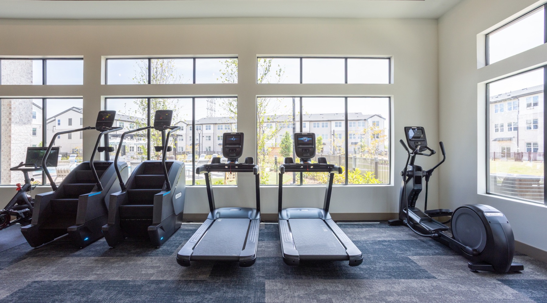 fitness center with rows of treadmills and modern style flooring